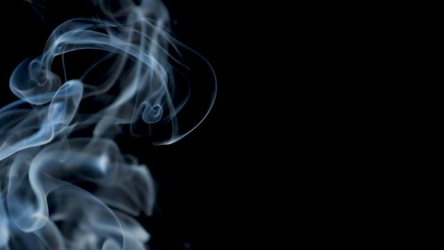 smoke- cloud background effect-  Black smoke floating through space against black background 