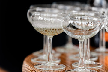 sparkling wine, champagne in glasses on the wooden table on black background in the restaurant. selective focus