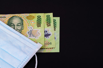 Money in Vietnam Dong, VND vietnamese mask health guard face earloop surgical for doctor, people Take care health and protect coronavirus disease COVID-19 and SMOG smoke fog PM2.5 on black background.