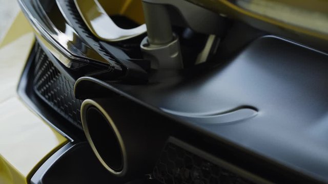 Modern yellow sport supercar exhaust system pipes close up