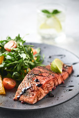 Hot smoked salmon with arugula salad, cherry tomato and orange. Healthy eating.