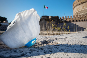 A protective mask symbol of the fight against the virus and the Italian flag flying solitary.