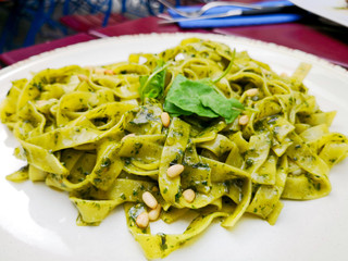 Pasta with pesto sauce and nuts on a the table