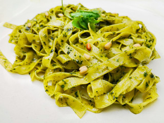 Pasta with pesto sauce and nuts on a the table