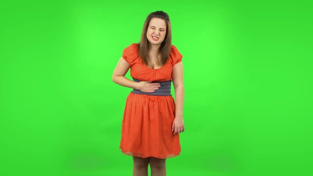 Cute girl is feeling very bad, her stomach hurting . Green screen