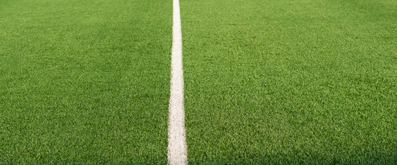 Artificial green grass and white border lines. Artificial turf for soccer field. Football field in...