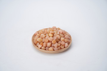 Air dried scallops on a wooden plate with a white background