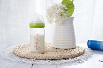 There is milk in the bottle, facing the sun under the windowsill