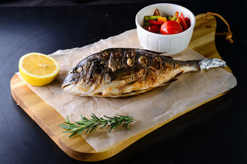 grilled dorada on a wooden board