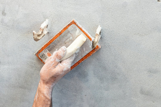 muratore con spugna per malta