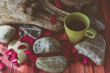 Tazza di the con petali legno e pietre