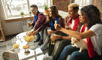 Togetherness. Excited people watching sport match, chsmpionship at home. Multiethnic group of friend, fans cheering for favourite national basketball, tennis, soccer, hockey team. Concept of emotions.