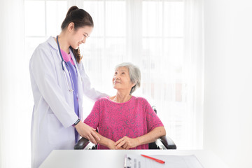 Fototapeta premium asian female doctor talk about rehabilitation process with old stroke patient in hospital, they feeling happy and smile, old asian people sitting on wheelchair, hand in hand, elderly healthcare