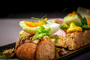 Bruschetta with tuna and herbs on black bread toast with egg. Delicious homemade food. restaurant menu. place under the text