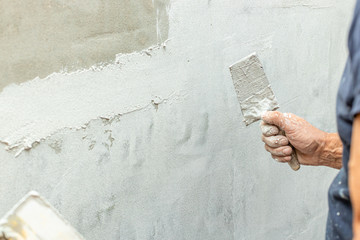 cazzuola con mano e muro