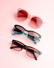 Sunglasses of various forms and colors in a row. Flat lay with fashion accessory sunglasses