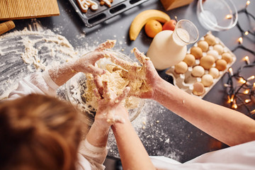 Close up view of brother with his little sister that preparing food on kitchen and have fun