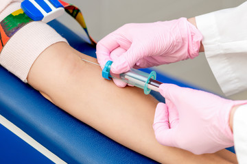 Nurse taking blood with syringe.