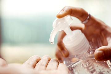 Hand pumping alcohol gel or sanitizer gel to others hand for washing, cleaning hand for kill the...