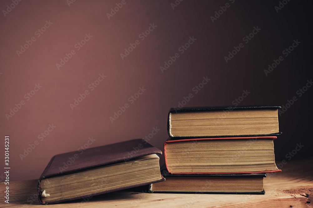 Poster vintage ancient books. pattern background for design. the book on a brown wooden table table and red