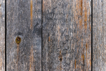 Outdoor wooden flooring from the planks. Knots, scratches and black lines between the boards. Texture for background.