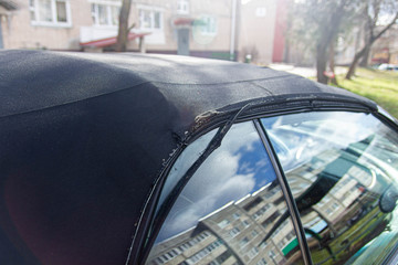 Convertible fabric roof repair, torn material, rubber seals.