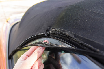 Convertible fabric roof repair, torn material, rubber seals.