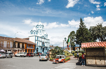 Colourful traditional houses and a blue & white Catholic church on the main plaza of Filandia, a typical Colombian town in the Quindio coffee region