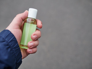 Concept of living in a new reality of coronavirus epidemic hysteria man's hand holding sanitizer...