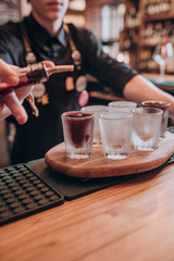 the bartender pours the tincture into the glasses