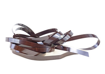 Magnetic audio cassette tangle. Old audio cassette unwound tape on white background. VHS Internal...