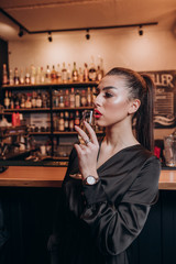 young beautiful girl in a black dress with a glass of champagne in her hands