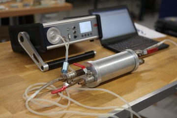 Radon gas radiation detectors testing. Dosimetrist holding a portable gamma radiation dosimeter set...