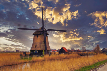 Classic Dutch windmill against sunset sky