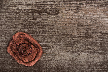 Top view of clay amulet with symbol on wooden surface