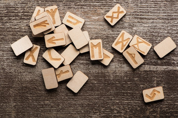 Top view of shamanic runes with symbols on wooden background