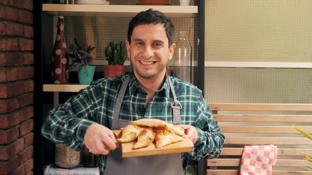 Man cooking empanadas argetinian pie, traditional bakery from argentina, chef filling dough in home with meat and vegetables, homemade spanish empanadas