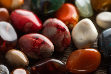 Close up view of shamanic colorful fortune telling stones on wooden background