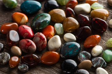 Colorful fortune telling stones on wooden background