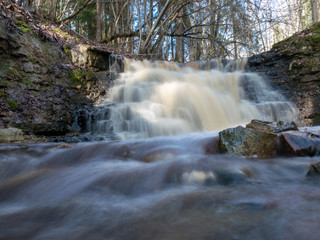 spring landscape with a small waterfall on a small wild river