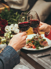 romantic dinner of man and woman with wine and flowers at a restaurant  dinner for two a glass of wine salad on the plate