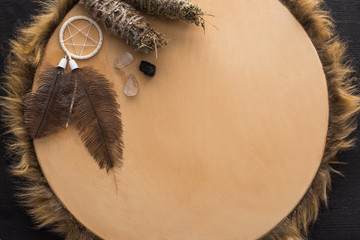 Top view of smudge sticks, crystals and dreamcatcher on tambourine on dark wooden background