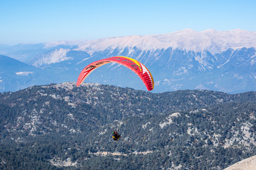 Paraglider flying over mountains