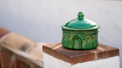 green pot over brick white fence