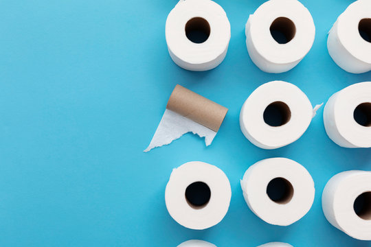 Empty used toilet roll next to a full roll of toilet paper