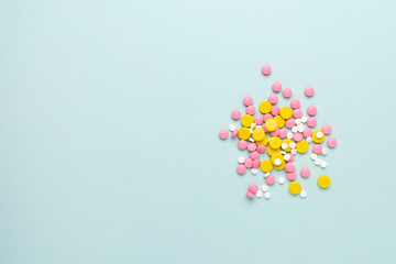 Colorful pharmaceutical medicine pills and tablets different medical drugs on blue background. Medicine flat lay.