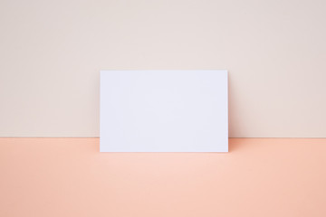 Mockup de tarjeta de visita horizontal sobre color blanco y salmón