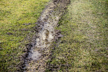 dirty mud road in winter with water on the road surface