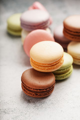 French macaroni cookies of different colors are on the gray table. Still life of confectionery.