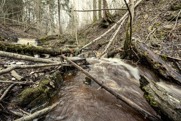 dirty waterfall on a small river in forest